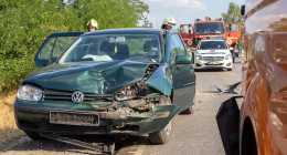 Egy zöld színű Volkswagen személygépkocsi, amelynek az eleje súlyosan megsérült, megáll egy úton. Tűzoltók, egy rendőrautó és egy tűzoltóautó van jelen. A helyszín egy nemrég történt közlekedési balesetre utal egy napsütéses napon.